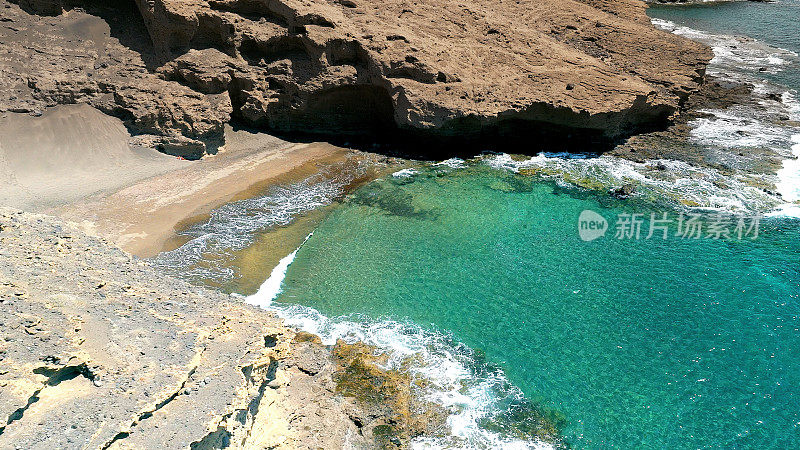 Aerial view of the hidden cove beach "La Rajita" at the natural reserve of "Monta?a Pelada" in Tenerife (Canary Islands). Drone shot